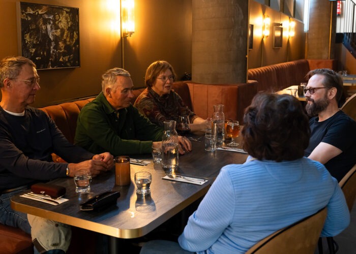 a group of tourists with a guide enjoy the cozy vibes in a fancy restaurant waiting to try local icelandic food