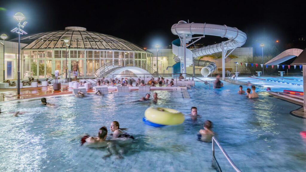 People enjoying geothermal pool at night