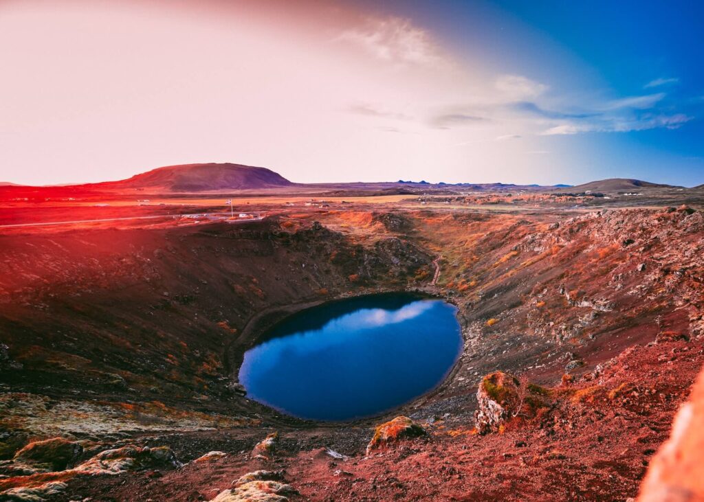 The reds of Kerid Crater in Iceland can be seen on a bright sunny day, making for one of the best day trips from Reykjavik!