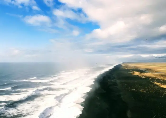 Black sand beach in Iceland with waves rolling ashore