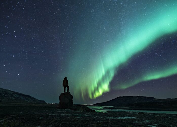 A human standing alone and admiring the Northern Lights