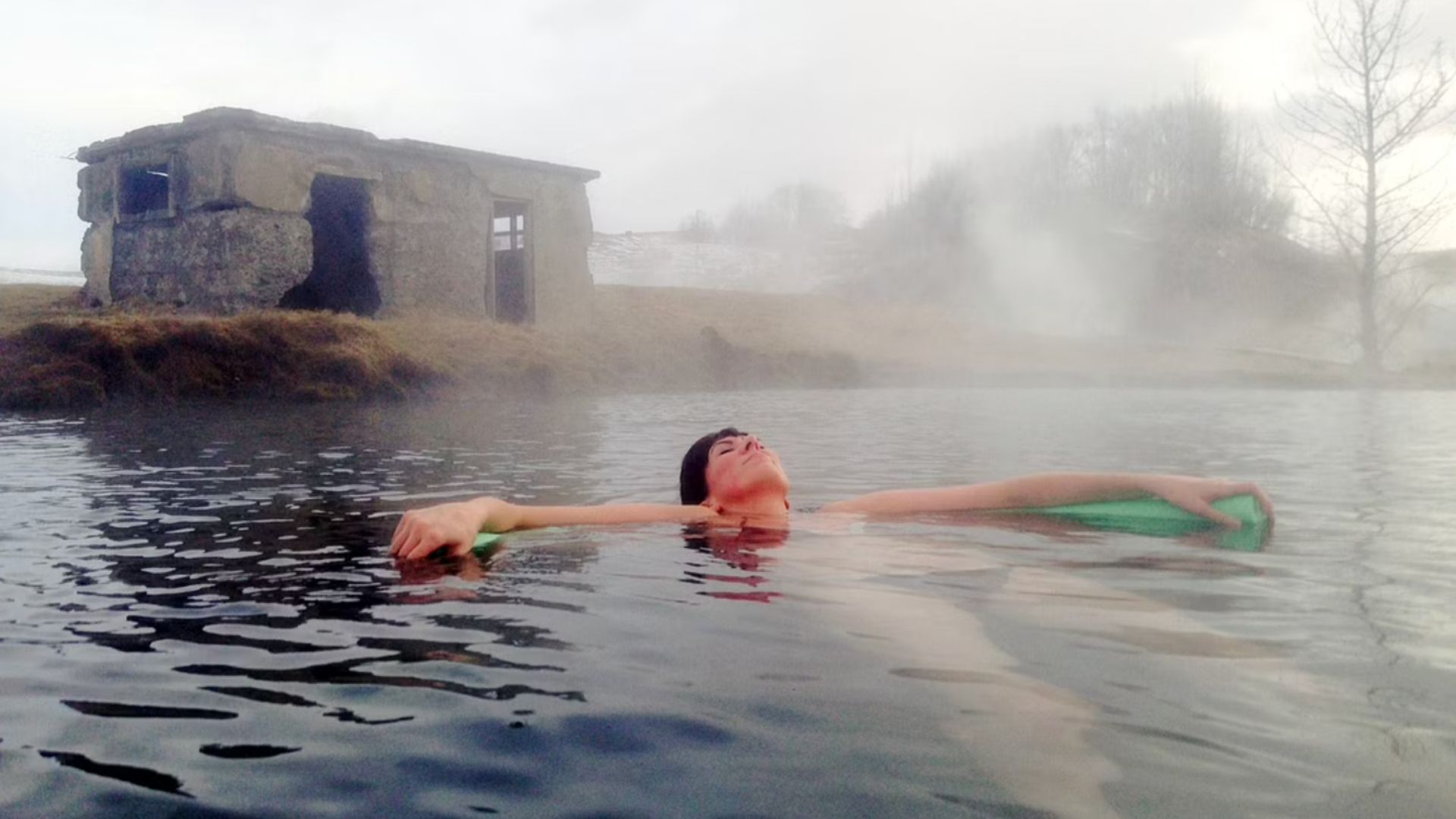 A tourist resting it the Secret Lagoon, geothermal pool in Iceland