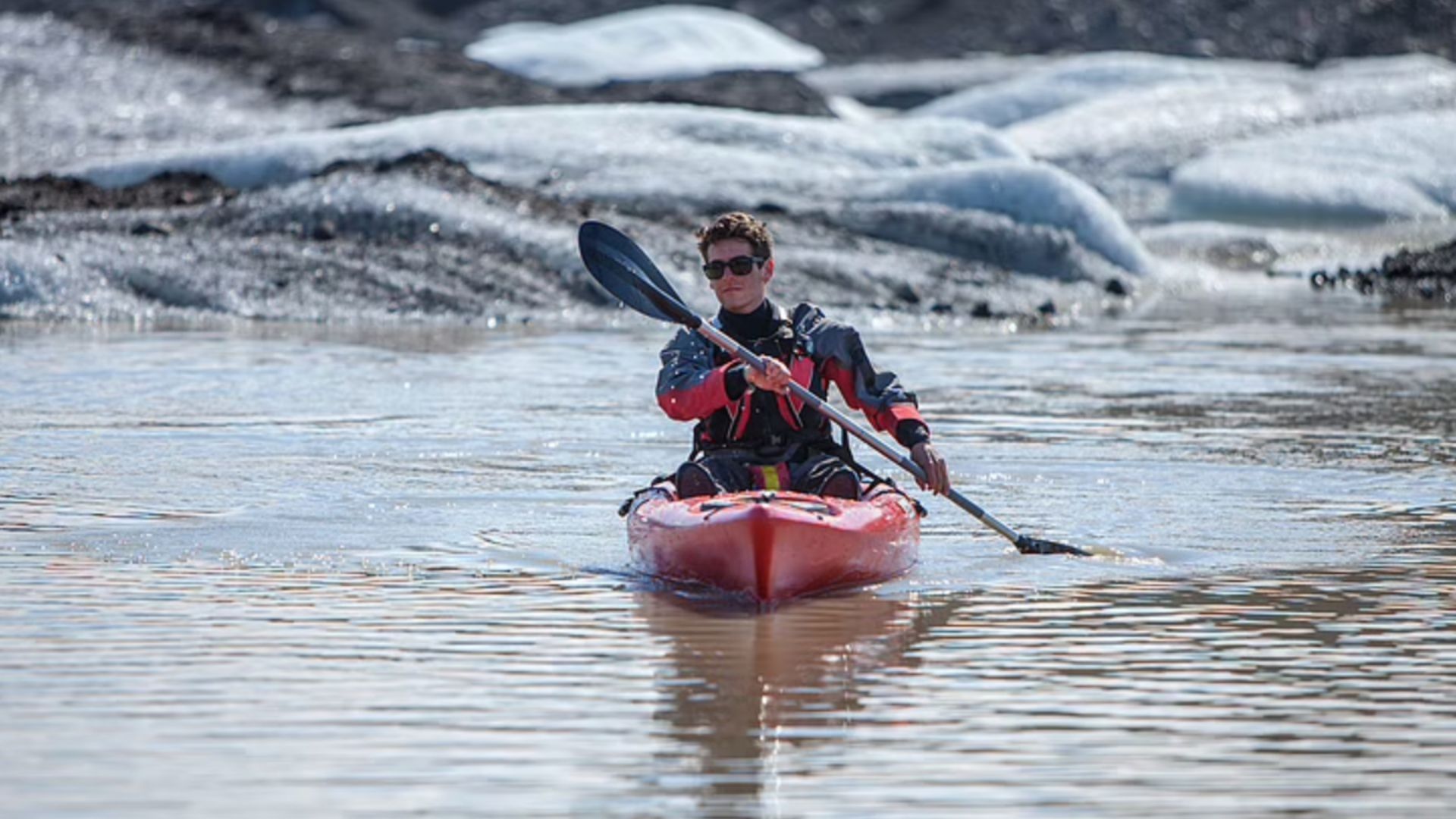 Tourist kayaking on the glacier lagoon
