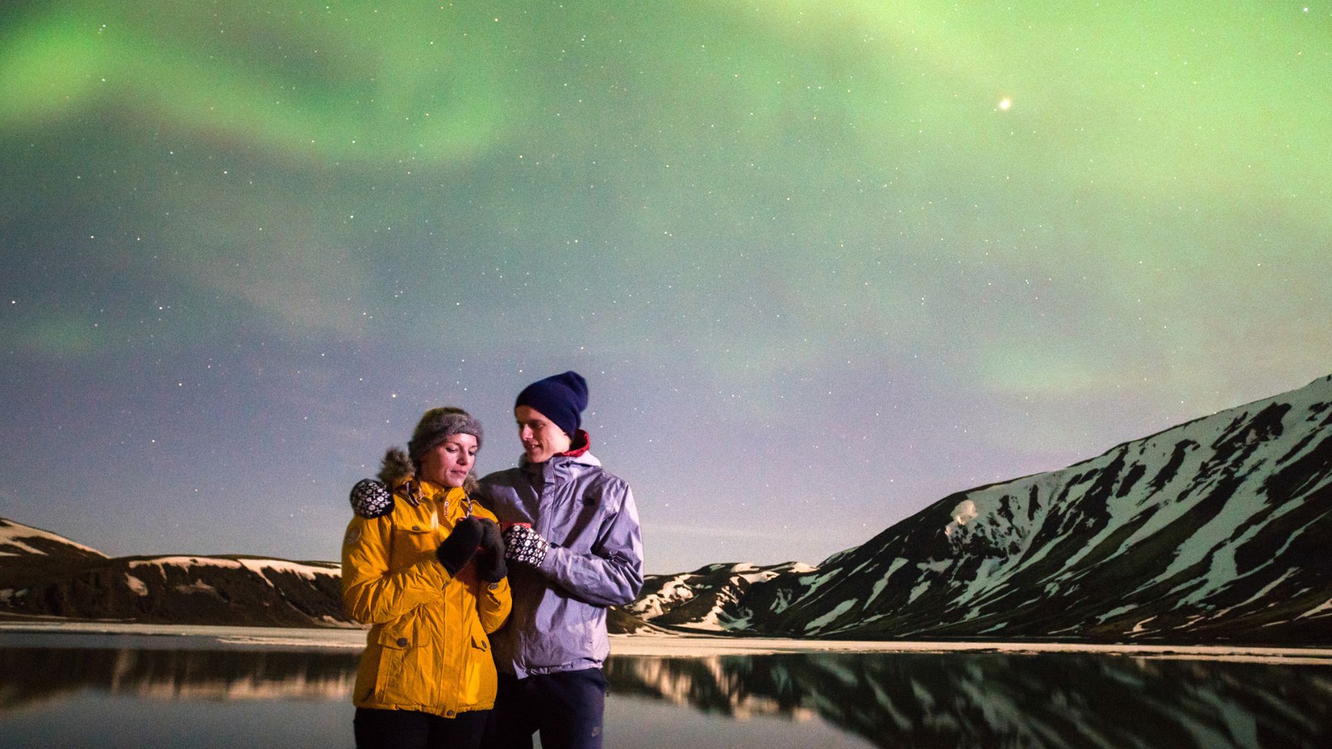 Tourists next to the lake during the Northern Lights tour