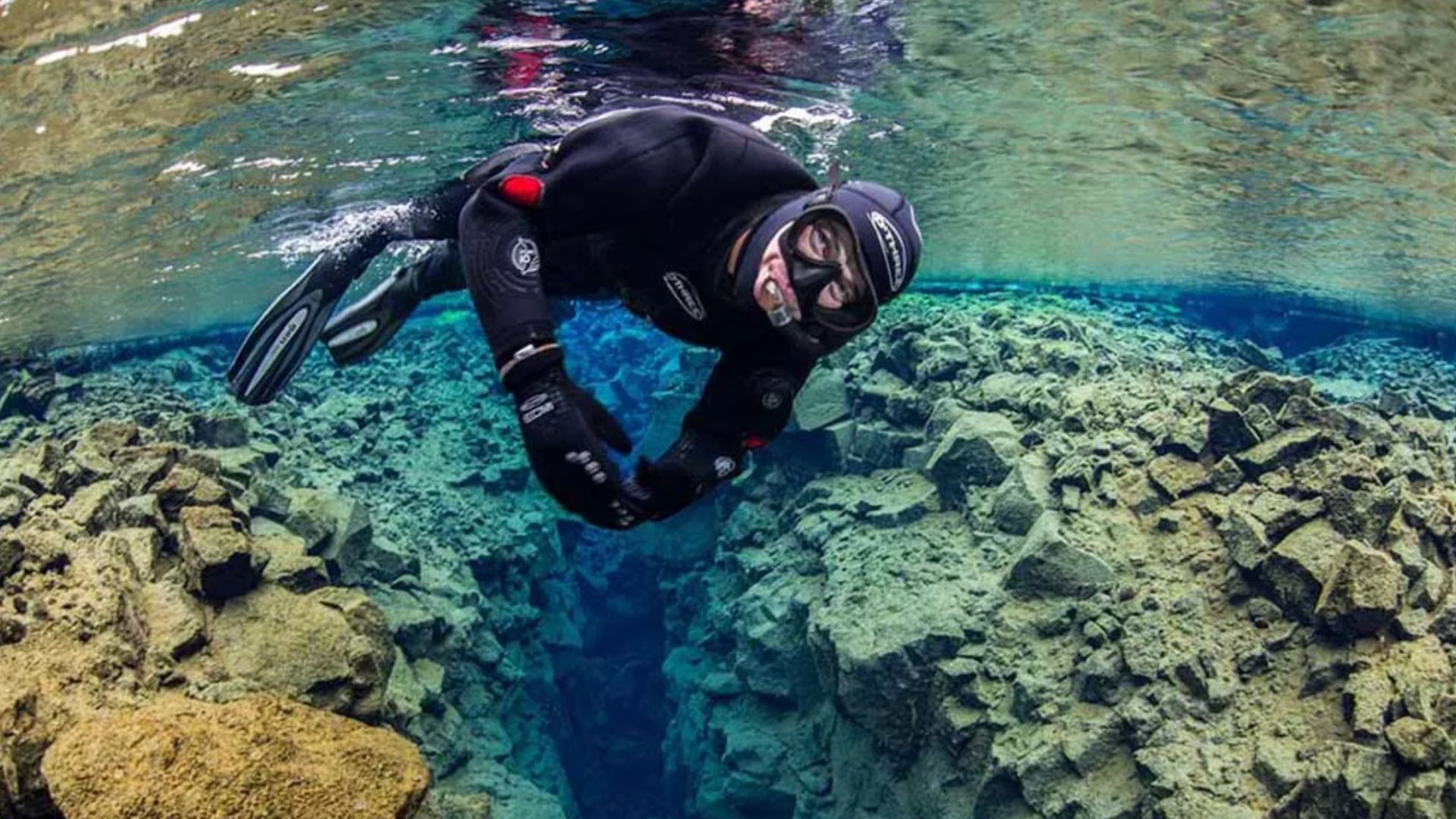 A tourist snorkeling in Silfra fissure