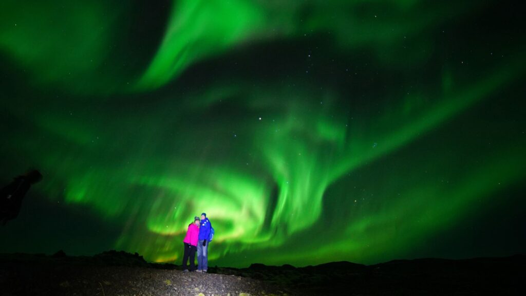 Tourists catching the Northern Lights in Iceland