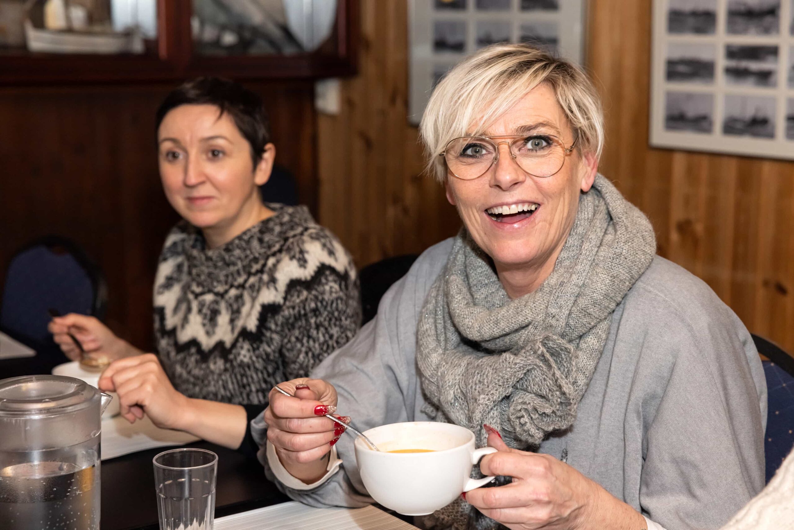 A guest smiling while enjoying a cup of Icelandic soup
