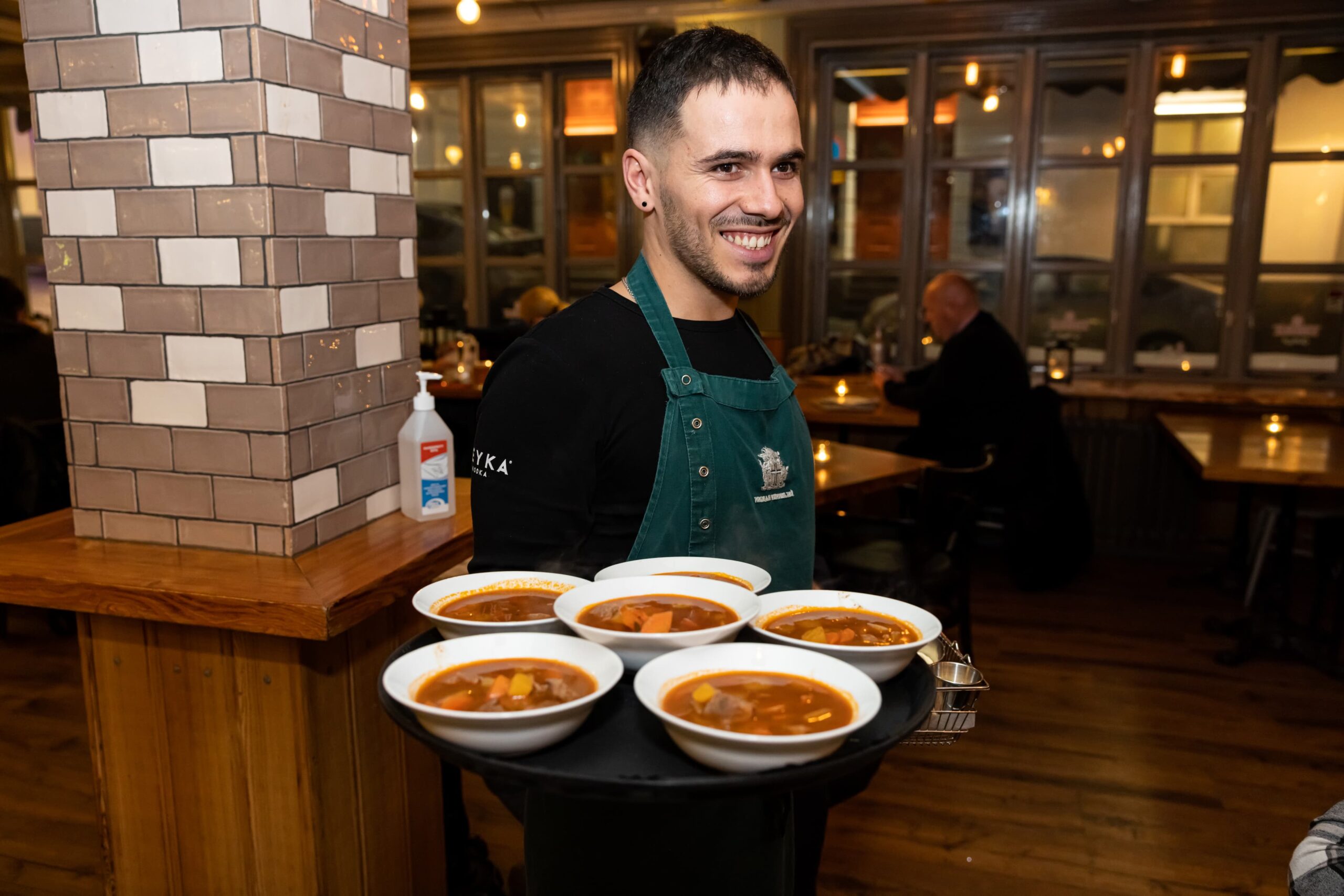 A waiter carrying plates of Icelandic Meat Soup