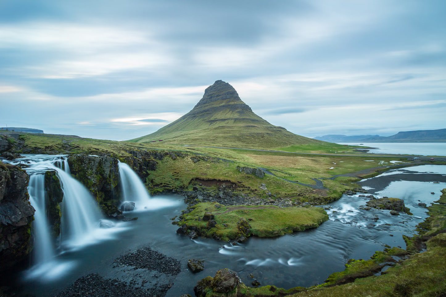 A picture of Kirkjufell with a waterfall to the left.