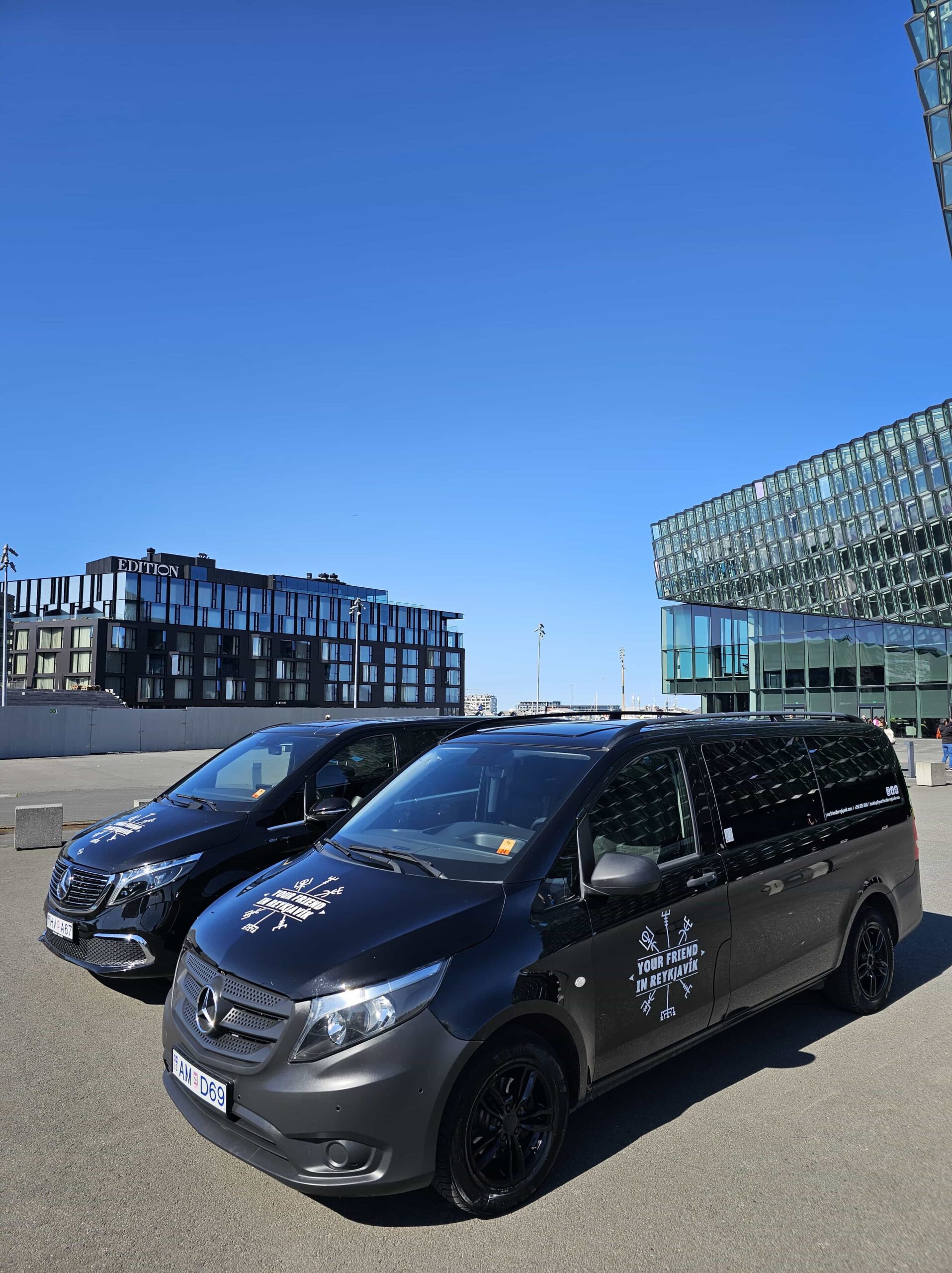Two Tour Vehicles from Your Friend in Reykjavik parked in front of the Harpa Concert Hall in Reykjavik