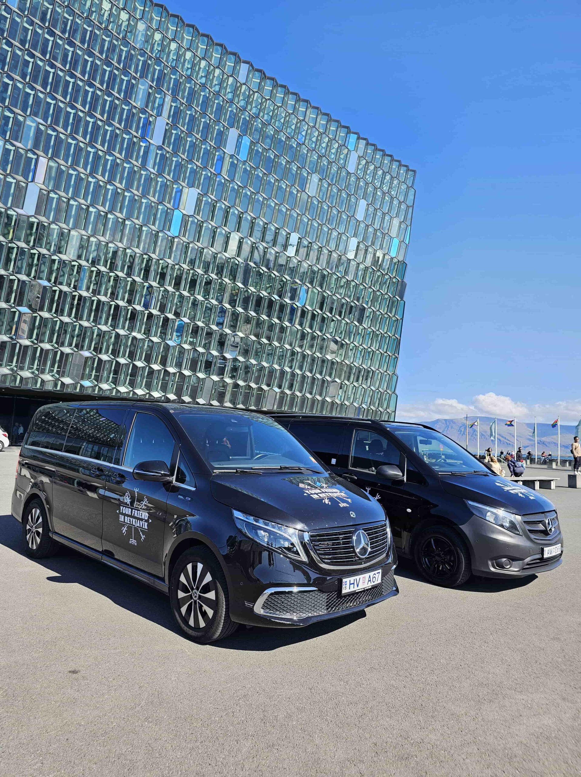 Two Tour Vehicles from Your Friend in Reykjavik parked in front of the Harpa Concert Hall in Reykjavik