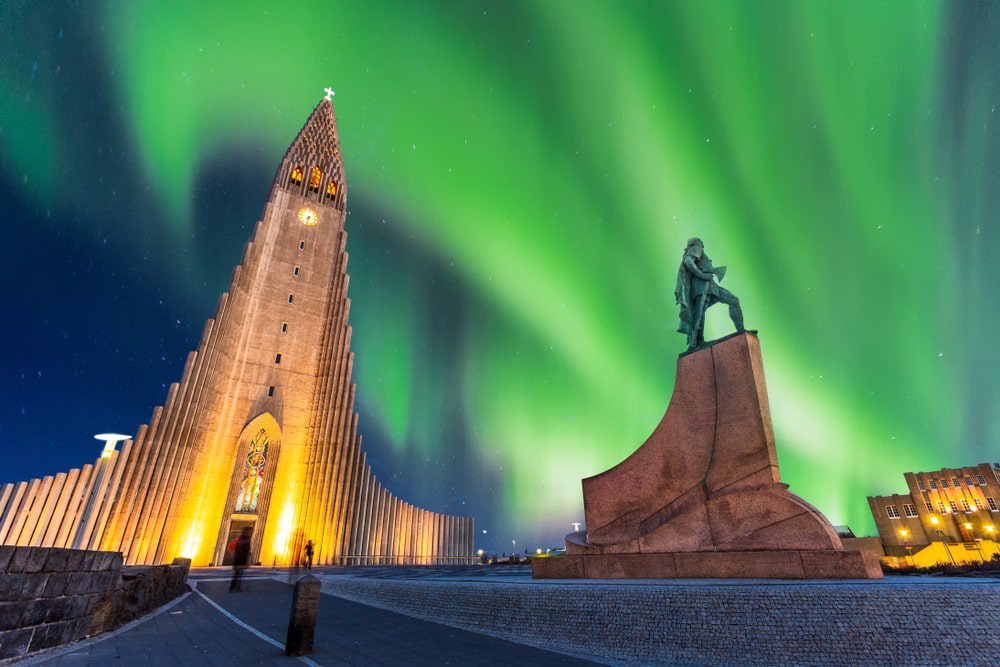 Northern lights dancing over Reykjavik with Hallgrimmskirkja pictured on the left side