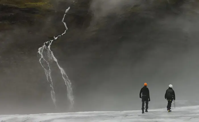 A lone hiker atop a glacier on the Golden Circle & South Coast