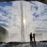 A large waterfall with people behind it