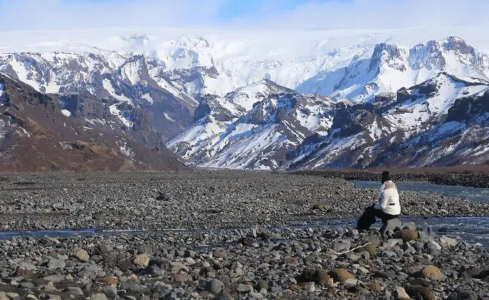 A large valley in snow capped mountains