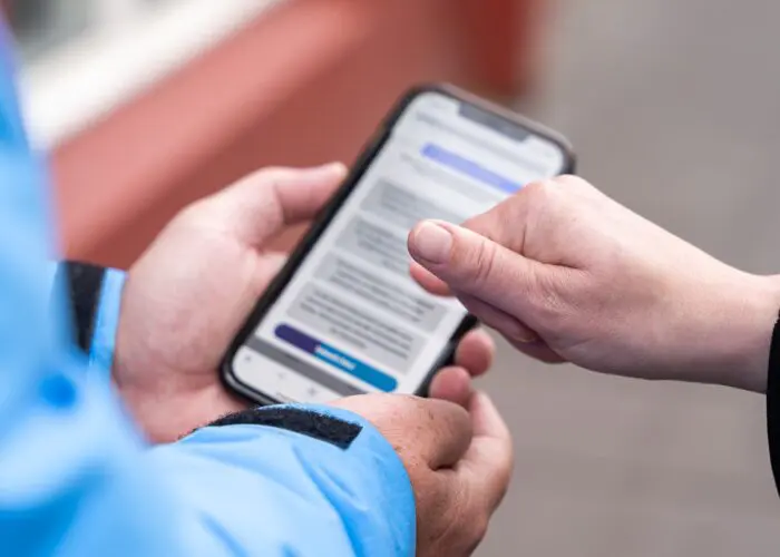 Two people navigating a browser on a phone