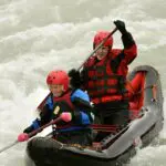 Two people in a black kayak on the Kayak River Ride adventure