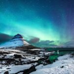 The Amazing Aurora: Northern lights dance above a snowy Icelandic landscape, casting a magical glow over the winter scenery