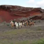 A group of horseback riders journey through the Icelandic wilderness, exploring the volcanic beauty of the land on the Volcanic Trails tour