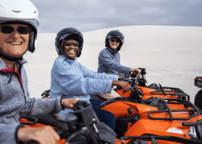 Three women sitting on parked ATVs during an off-road tour in Iceland