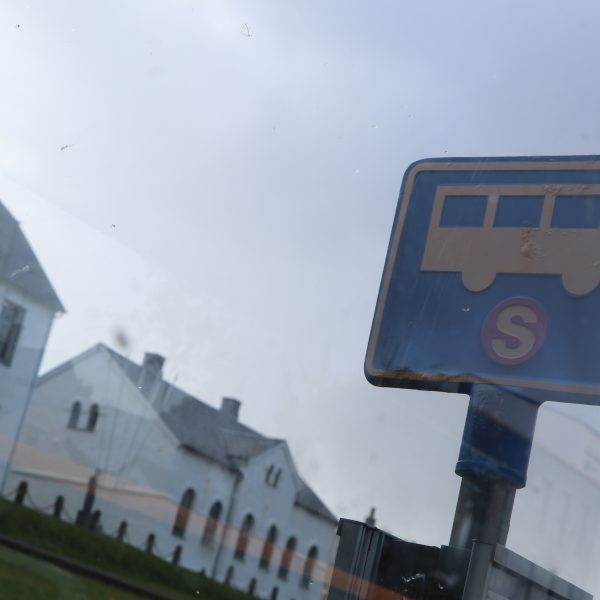A Strætó bus stop sign caught in the reflection.